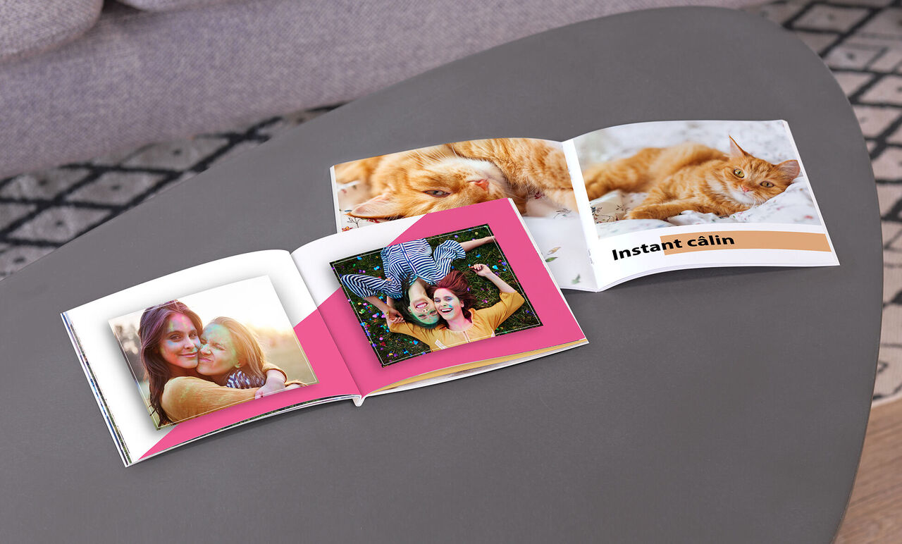 Un álbum de fotos abierto con páginas coloridas y fotos de amigos y un gato.