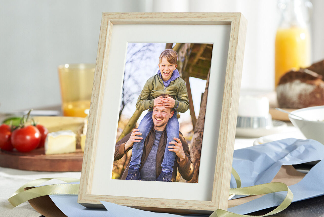 foto 10x15 con marco de madera blanco de un padre y un hijo disfrutando.