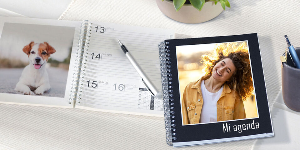 Un cuaderno personalizado con una foto en la portada y un calendario abierto sobre una mesa