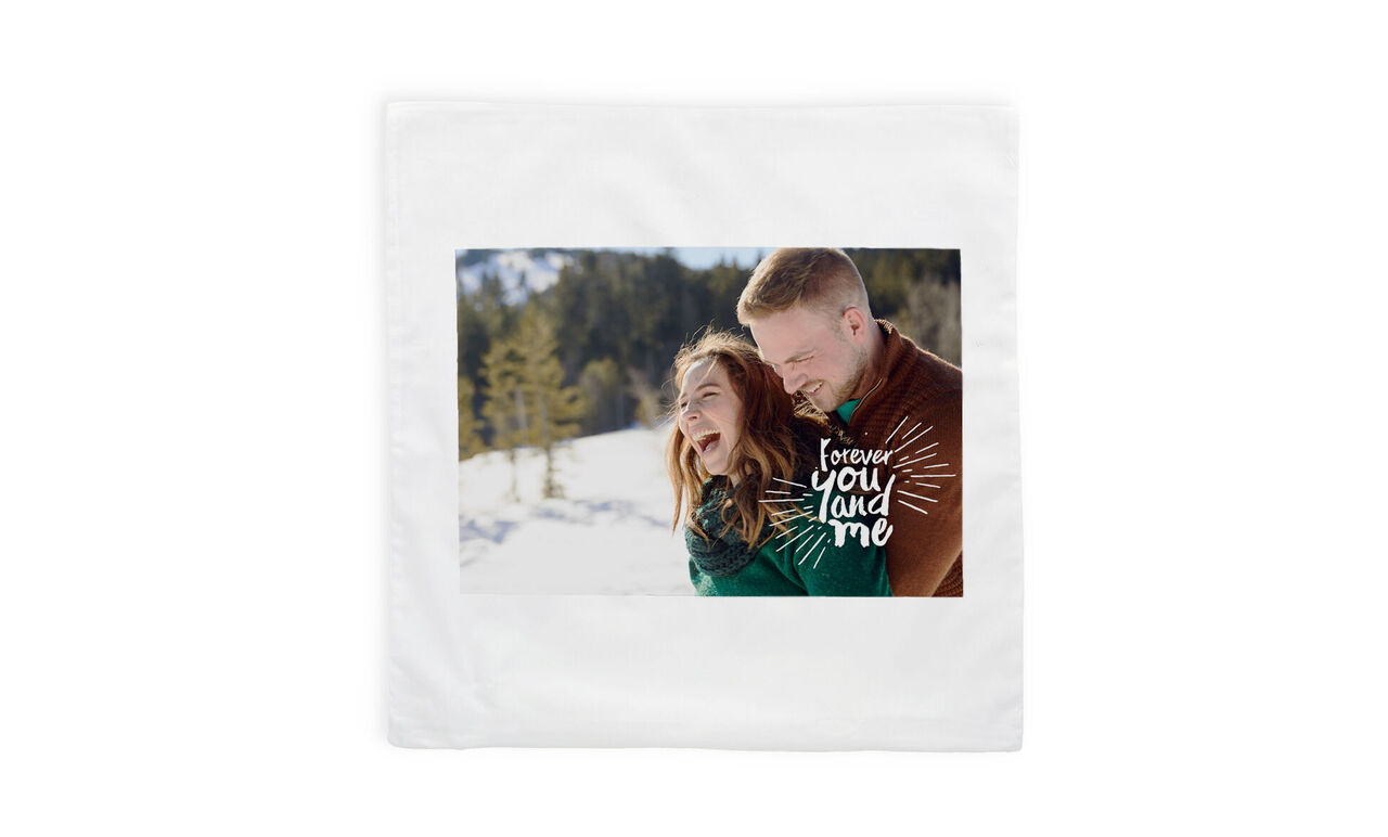 Una pareja feliz se abraza en un paisaje invernal rodeado de árboles cubiertos de nieve.