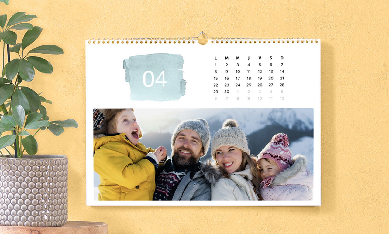 Familia disfrutando de un hermoso día en la nieve con un calendario al fondo