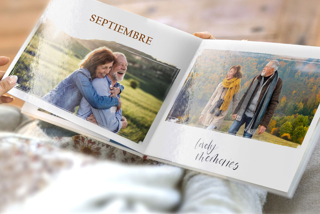 Dos personas en un fotolibro, abrazándose al aire libre, con un campo verde al fondo.