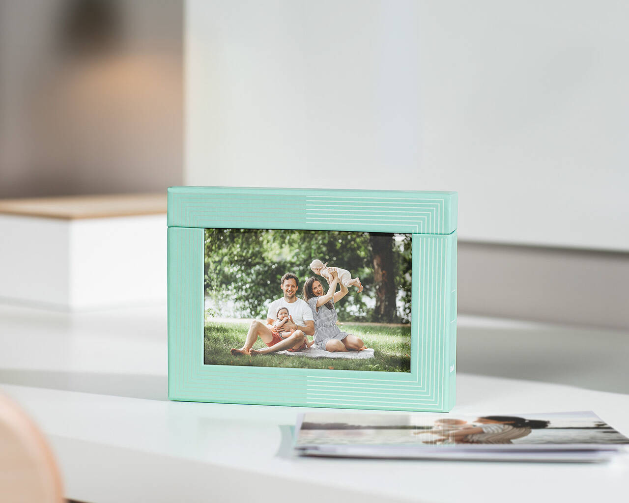 Un marco de fotos decorado con amor con una foto familiar en un parque. Árboles verdes y luz brillante de fondo.
