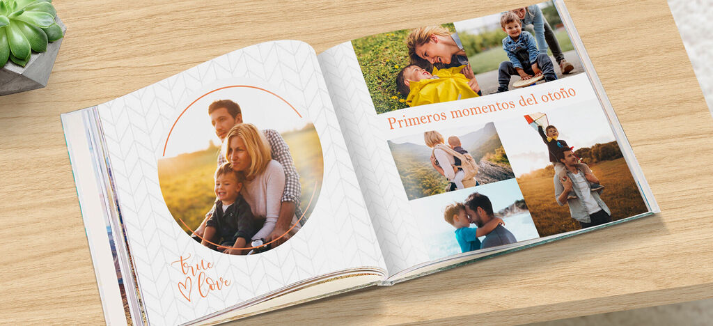 Un fotolibro abierto con fotos de momentos familiares al aire libre sobre una superficie de madera.