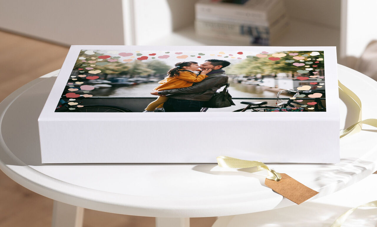 Una feliz pareja se abraza frente a un fondo romántico con corazones en tonos pastel