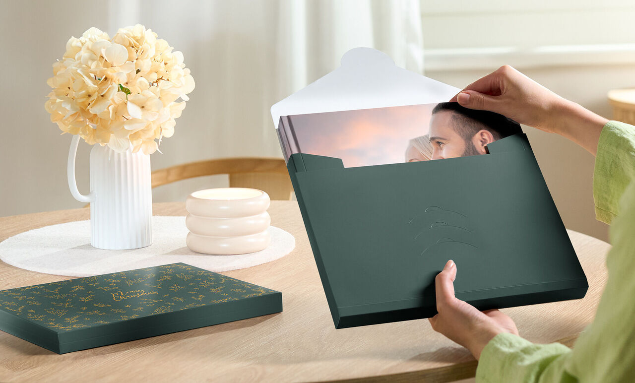 Una persona saca una foto de una caja verde en una mesa.