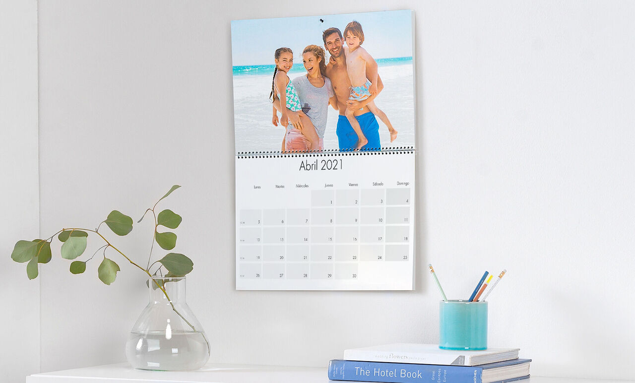 Familia feliz posando frente a un calendario del mes de abril.