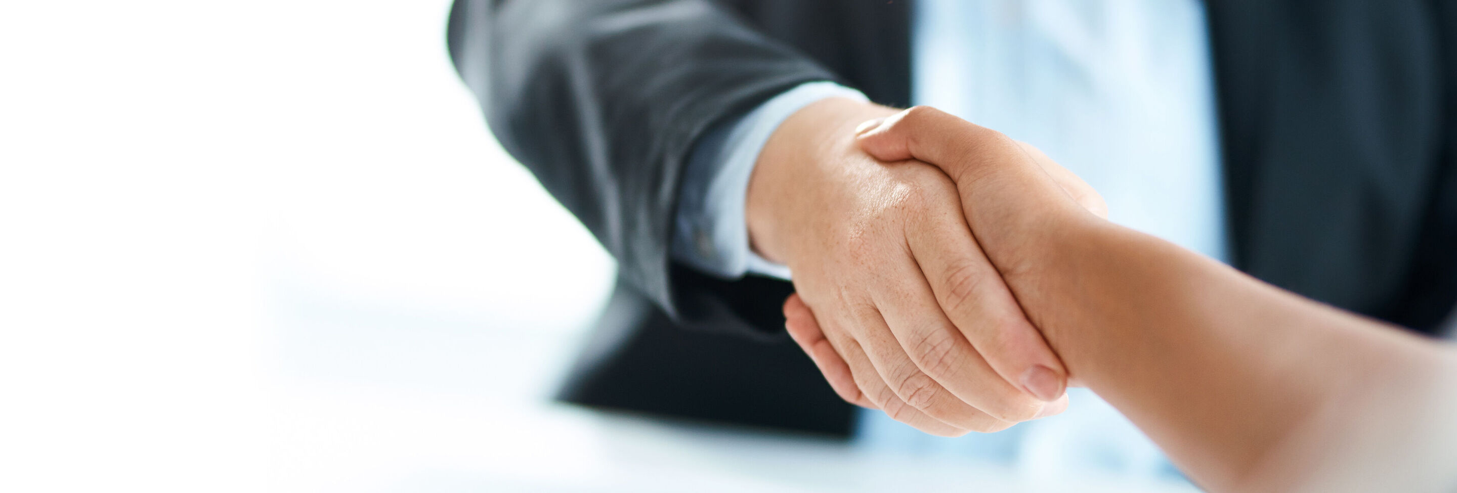 Dos personas se dan la mano en un entorno de negocios